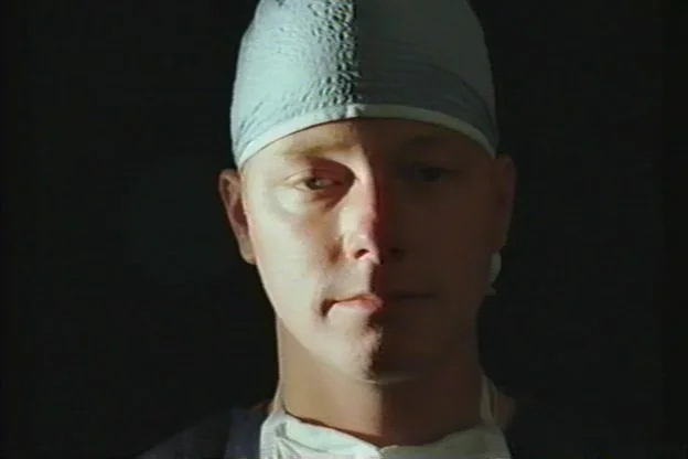 Jon Tojek on set in surgical cap and mask, July 13, 1997